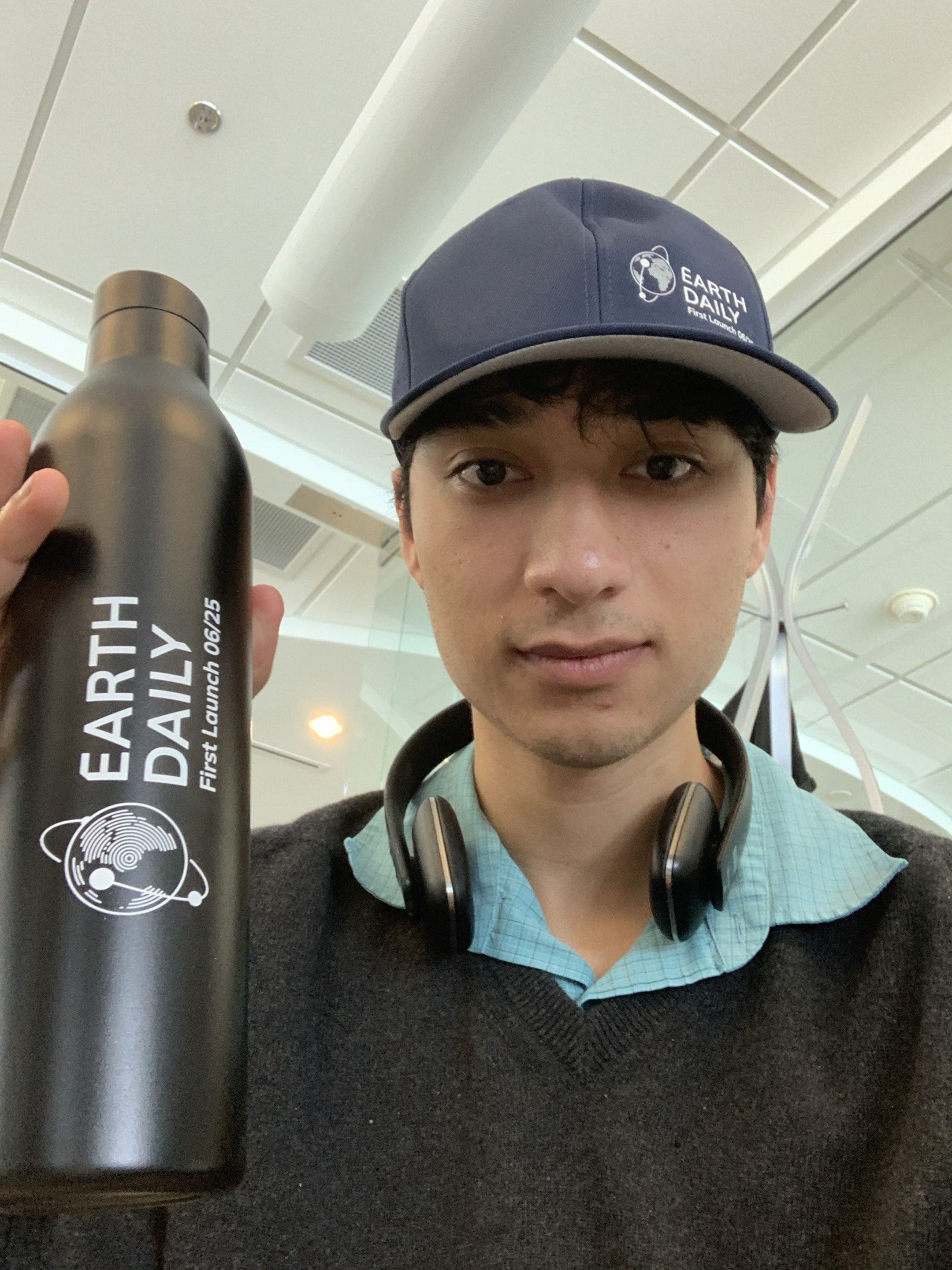 Sam wearing EarthDaily gear and holding an EarthDaily water bottle.